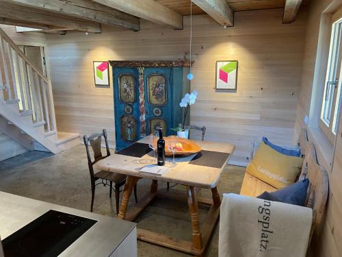 a room with a table with a bottle of wine on it at das Neni - das bioChalet im Montafon in Schruns-Tschagguns