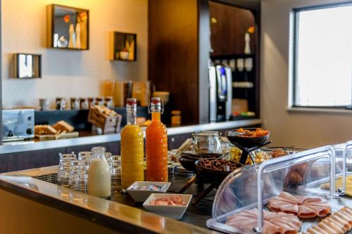 a table with food on a counter in a restaurant at Comfort Aparthotel Bordeaux Begles Arena in Bègles