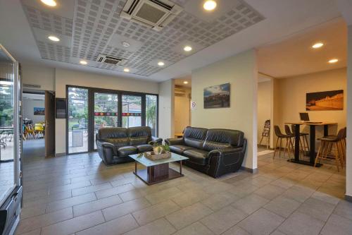 a living room with two leather couches and a table at Comfort Aparthotel Carcassonne in Carcassonne