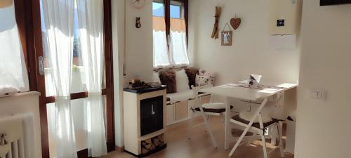 Camera bianca con tavolo, tavolo e sedie di Casa Memole a Levico Terme
