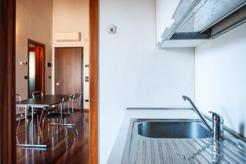 a kitchen with a sink and a table with chairs at Alba dei Grappoli in Spresiano