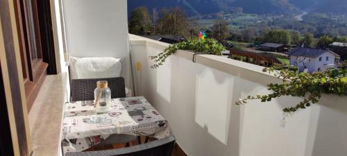 un tavolo su un balcone con una bottiglia di vetro sopra di Casa Memole a Levico Terme