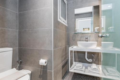 a bathroom with a sink and a toilet at Oasis Hotel in Perama