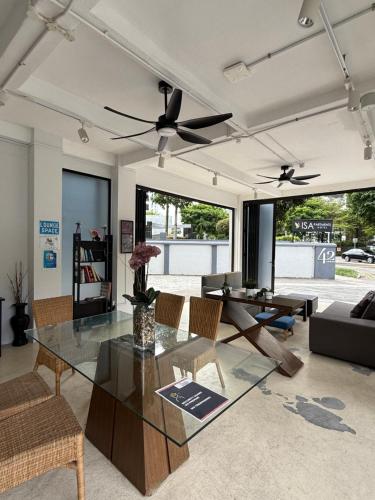 a living room with a glass table and chairs at ISA Hotel Amber Road in Singapore