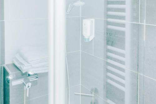 a bathroom with a shower with a phone in it at Fair Hotel Mönchengladbach City in Mönchengladbach