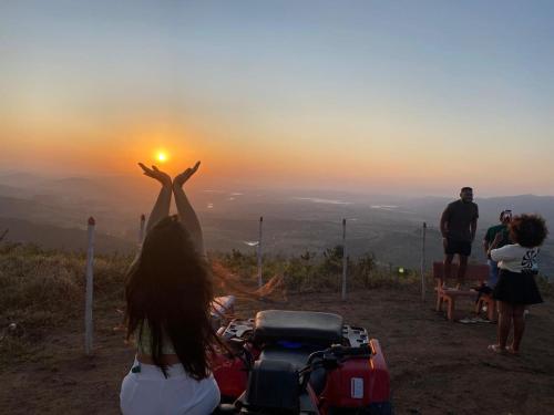 a woman standing on top of a mountain with her arms in the air at FLAT 228 - Hotel Pedra do Rodeadouro-Bonito-PE in Bonito