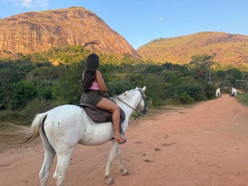 a woman riding a white horse on a dirt road at FLAT 228 - Hotel Pedra do Rodeadouro-Bonito-PE in Bonito