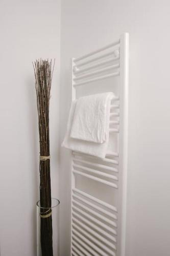 - un réfrigérateur blanc avec une serviette et un vase avec une serviette dans l'établissement Le Repaire 830 - Appartement 6 personnes - Saint Lary Soulan, à Saint-Lary-Soulan