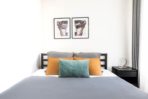 a bedroom with a white bed with orange and blue pillows at Ca' San Marco - A Due Passi Dalla Basilica in Vicenza
