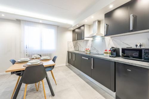 une cuisine avec une petite table et un micro-ondes dans l'établissement Merveille de Clarisse en ville, à Annecy