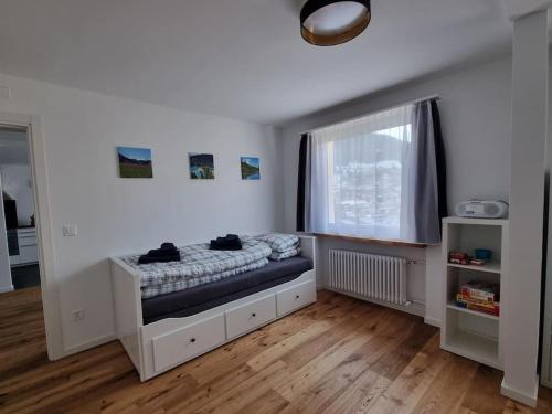 une petite chambre avec un lit et une fenêtre dans l'établissement Schöne neue 2,5 Zimmer Wohnung in Savognin, à Savognin