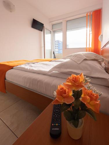 a bedroom with a bed and a remote control on a table at HOTEL DUNĂREA in Mamaia