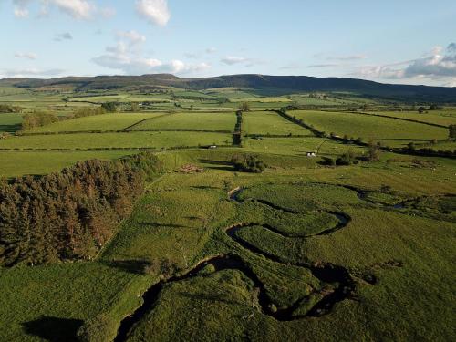 an aerial view of a river in a field at Westfield House Farm in Rothbury