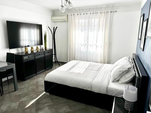 une chambre avec un lit, une commode et un bureau dans l'établissement Studio vue mer terrasse à 1min des plages, à Juan-les-Pins