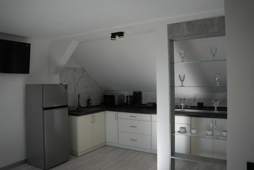 a kitchen with white cabinets and a refrigerator at West Hotel in Mostiska