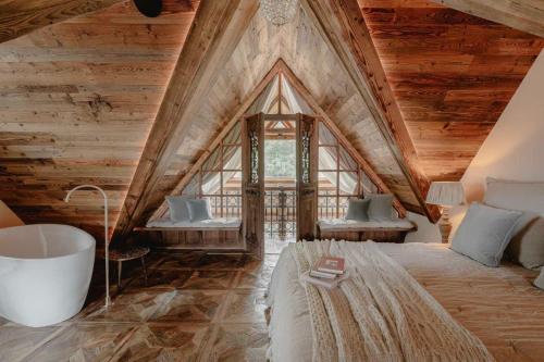 a bedroom with a large bed and a bath tub at Villa Vena in Zakopane