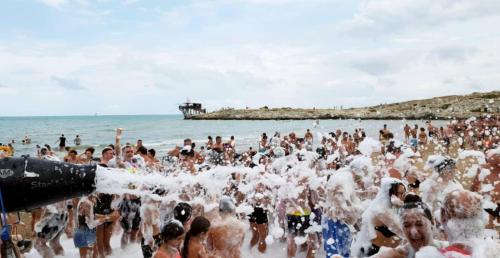a crowd of people playing in the water at the beach at Villaggio Porticello Mare in Vieste