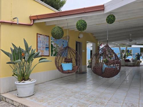 a building with two hanging baskets on the side of it at Villaggio Porticello Mare in Vieste