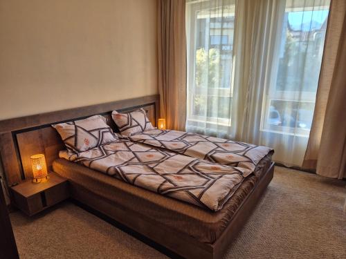 a bedroom with a bed and a window at Apartment Melania in Complex Royal Towers in Bansko