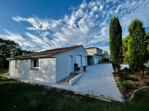 a small white house with a gravel driveway at Chambre indépendante au calme, petit-déjeuner inclus in Arthès
