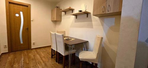 a dining room with a table and white chairs at Republicii Residence 2 in Ploieşti