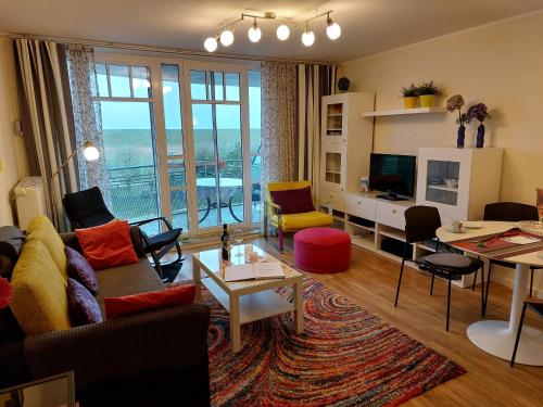 a living room with a couch and a table with chairs at de Dang in Dorum-Neufeld