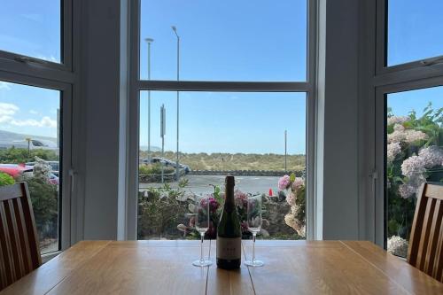 a bottle of wine sitting on a table in front of a window at Barmouth beach ground level in Barmouth