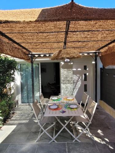 - une table et des chaises sur une terrasse avec un toit dans l'établissement Maison au bord de la mer, à Poggio-Mezzana
