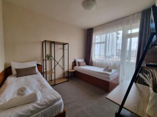 a room with two beds and a window at Dezudava Family Hotel in Sandanski