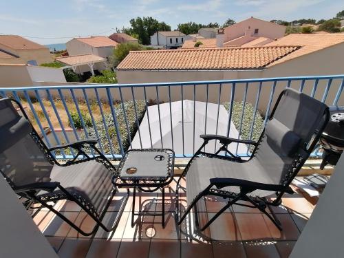un balcon avec deux chaises et une table dans l'établissement La Côte de Lumière, à La Tranche-sur-Mer