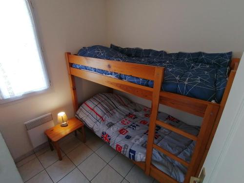 - une petite chambre avec des lits superposés et une table de nuit dans l'établissement La Côte de Lumière, à La Tranche-sur-Mer