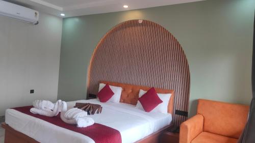 a bedroom with a large bed with red and white pillows at Shivanta Resort and Hotel in Deoghar