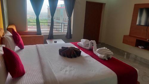a hotel room with a bed with towels on it at Shivanta Resort and Hotel in Deoghar
