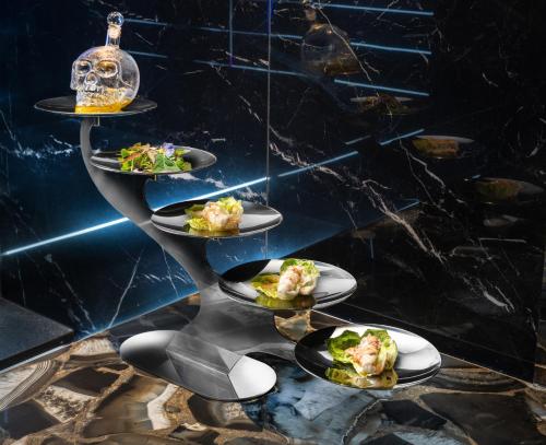 a shelf with three plates of food on a table at The Plein Hotel - Small Luxury Hotels of the World in Milan