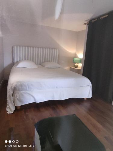 une chambre avec un lit blanc et une table dans l'établissement Maison des Bois, à Bièvres