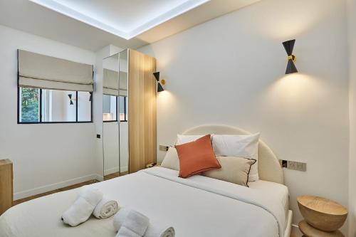une chambre avec un lit avec des oreillers et une fenêtre dans l'établissement Charming flat Jardin du Luxembourg Montparnasse, à Paris