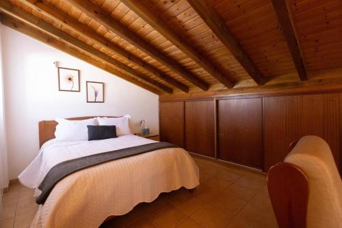 a bedroom with a bed and a wooden ceiling at Casa dos Avos in Faro