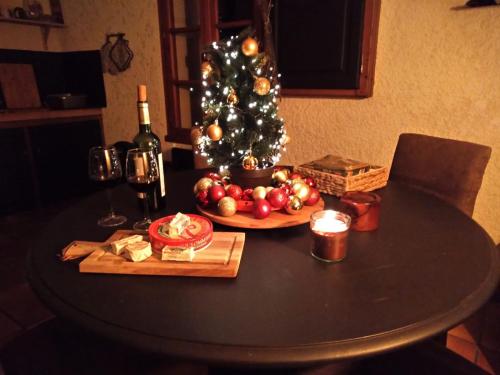 - une table avec un arbre de Noël et une bouteille de vin dans l'établissement Vakantiehuis Belle Jeanne, à Saint-Colomb-de-Lauzun