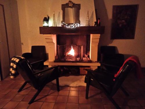 - un salon avec une cheminée, 2 chaises et une table dans l'établissement Vakantiehuis Belle Jeanne, à Saint-Colomb-de-Lauzun