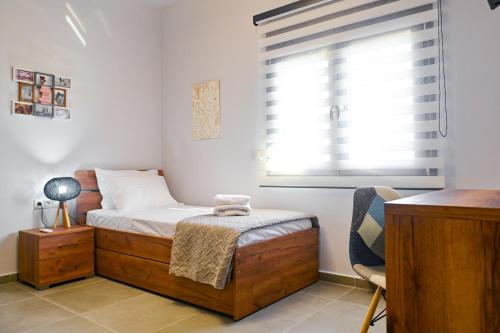 a small bedroom with a bed and a window at Nychome in Ayía Marína