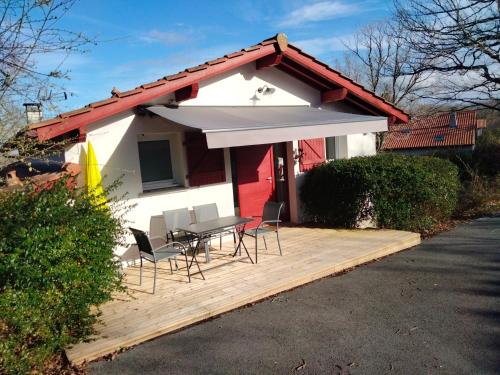 a patio with a table and chairs in front of a house at T3 cadre champêtre Saint Jean de Luz in Saint-Pée-sur-Nivelle