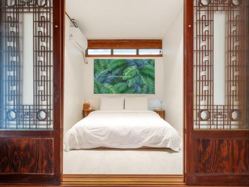a bedroom with a bed and a painting on the wall at Exclusive House Hanok Stay 'Soo Hanok' in Suncheon