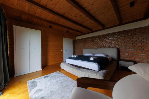 a bedroom with two beds and a brick wall at Vdoma Karpaty in Vilshynki