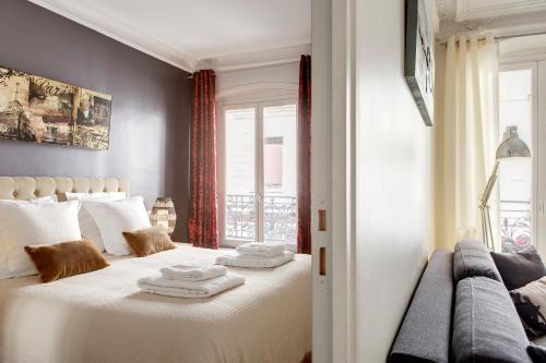 une chambre avec un grand lit blanc avec une fenêtre dans l'établissement Beauregard Design residence, à Paris