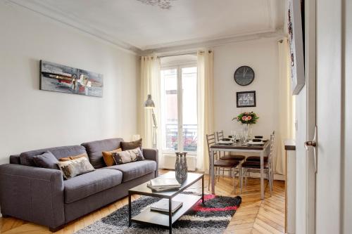 un salon avec un canapé et une table dans l'établissement Beauregard Design residence, à Paris