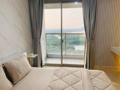 a bedroom with a bed and a large window at Apartment Goldcoast-Studio Room in Jakarta