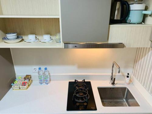 a small kitchen with a sink and a stove at Apartment Goldcoast-Studio Room in Jakarta