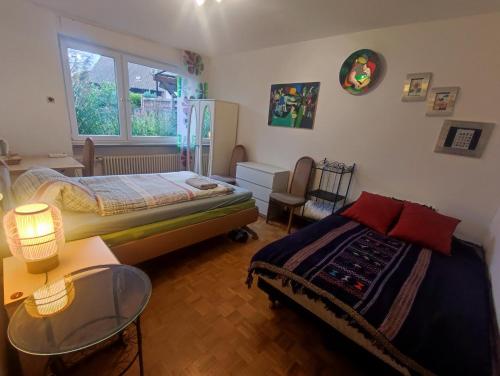 a bedroom with a bed and a table and a window at Uni-nähe Unterkunft mit Garten in Bochum