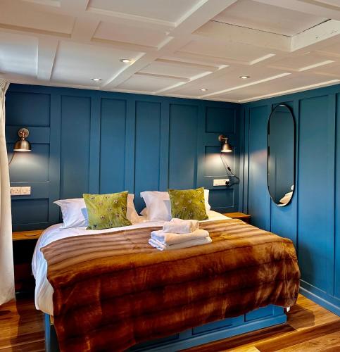 a bedroom with blue walls and a large bed at Octon Cottages Luxury 1 and 2 Bedroom cottages 1 mile from Taunton centre in Taunton
