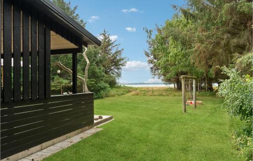 a house with a green yard with a playground at Strandbo in Thyholm